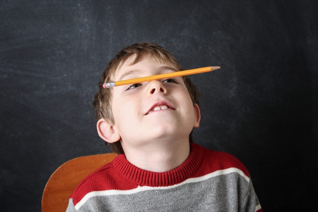 boy balancing pencil on his nose