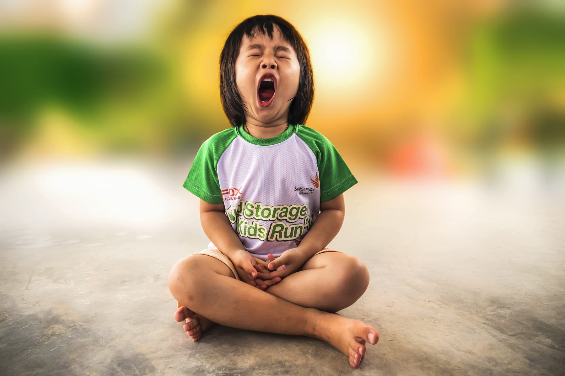 child yawning in meditative pose